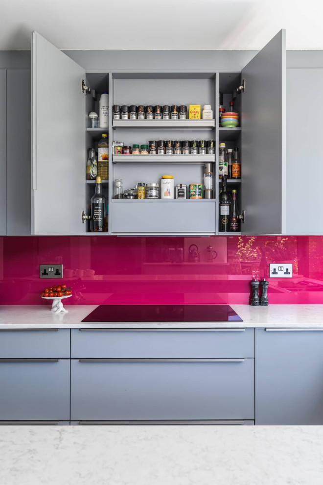 This is an example of a small modern u-shaped kitchen/diner in Sussex with a double-bowl sink, flat-panel cabinets, grey cabinets, quartz worktops, pink splashback, grey floors and white worktops.