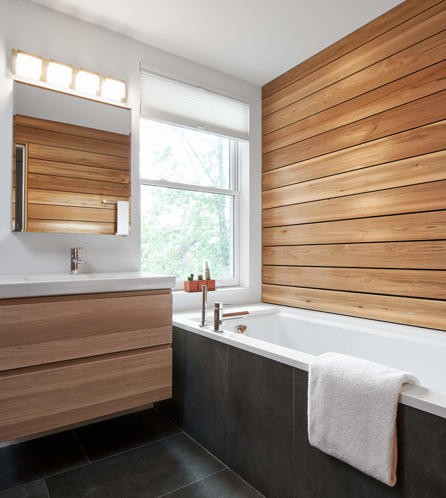 Mid-sized contemporary master bathroom in Ottawa with flat-panel cabinets, medium wood cabinets, a drop-in tub, a curbless shower, a two-piece toilet, white walls, ceramic floors, a wall-mount sink and an open shower.