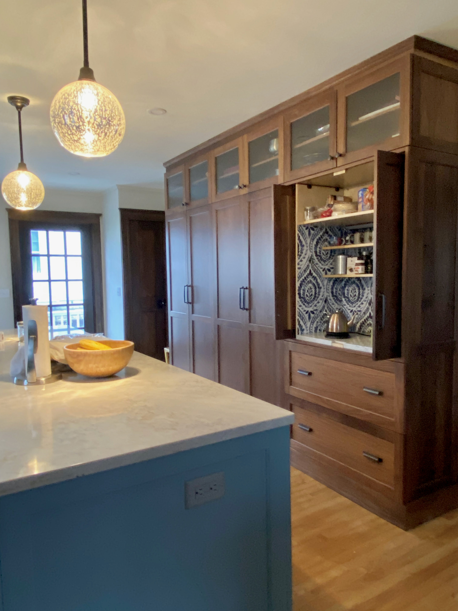 Walnut pantry cabinets recall the original Craftsman style of this 1920s home