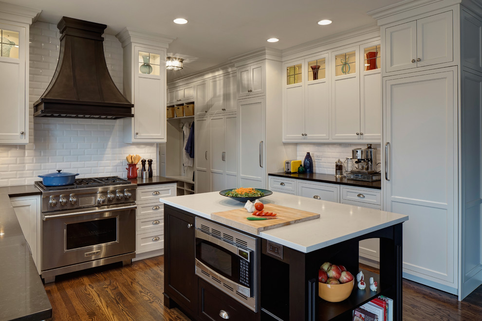 Photo of a mid-sized traditional u-shaped eat-in kitchen in Chicago with an undermount sink, beaded inset cabinets, white cabinets, granite benchtops, white splashback, subway tile splashback, stainless steel appliances, medium hardwood floors and with island.
