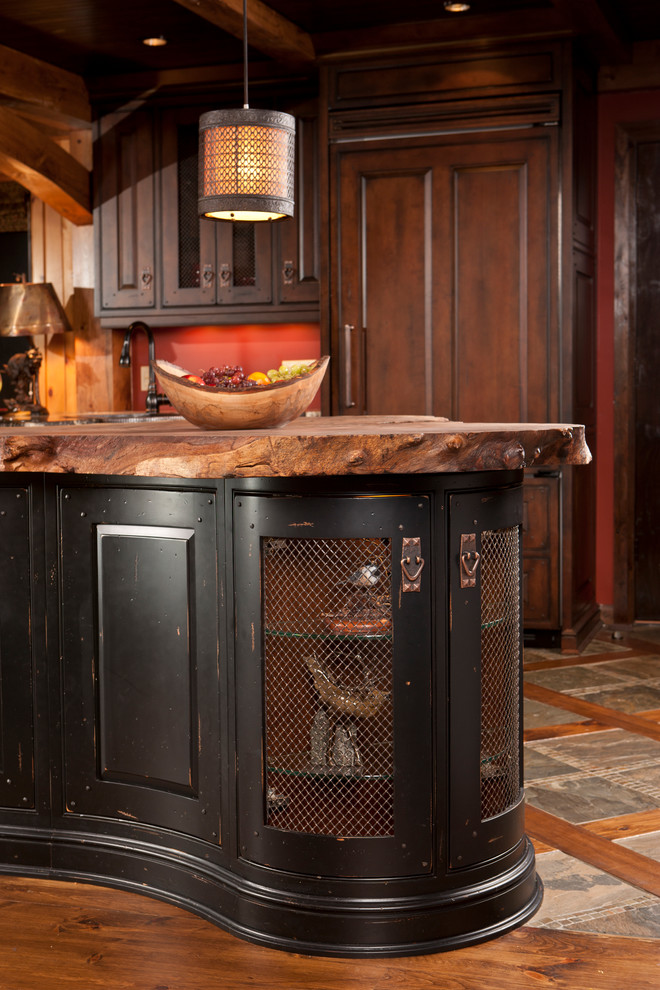 Inspiration for a mid-sized rustic u-shaped medium tone wood floor home design remodel in Toronto with raised-panel cabinets, distressed cabinets, granite countertops, paneled appliances and an island