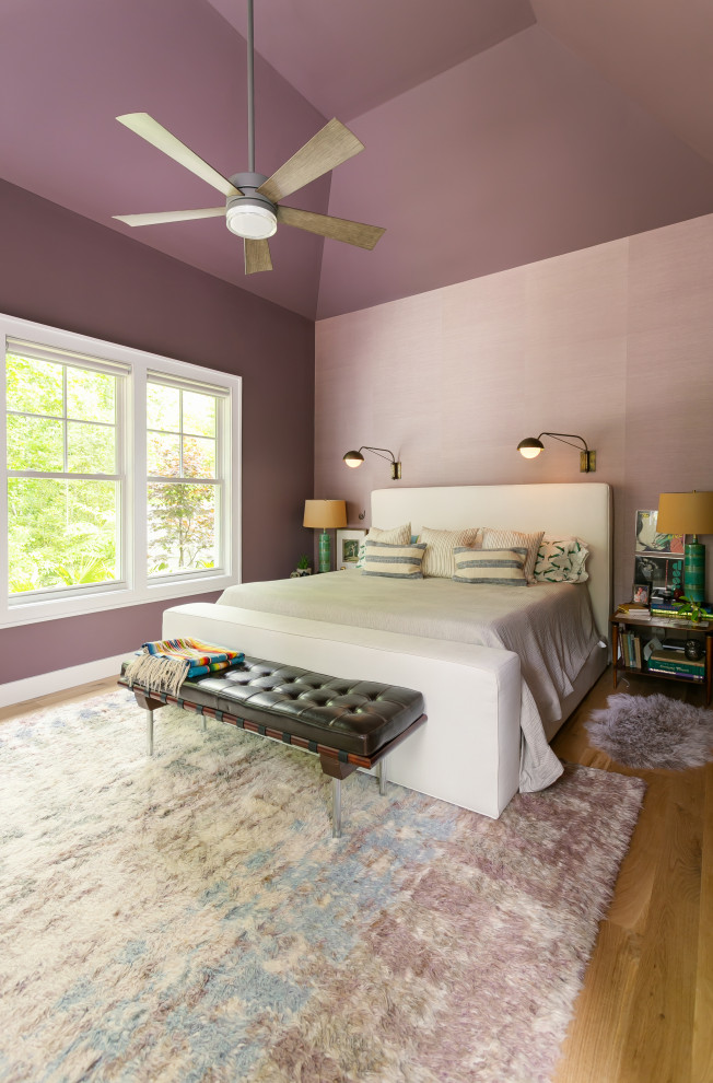 Réalisation d'une grande chambre parentale tradition avec un mur violet, parquet clair et un plafond voûté.