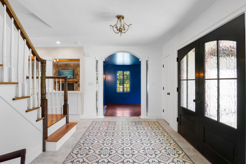 Inspiration for a mid-sized french country ceramic tile and multicolored floor foyer remodel in New York with white walls and a dark wood front door
