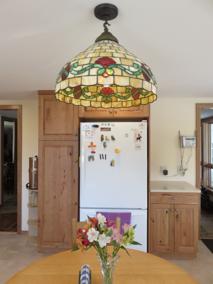 Foto på ett avskilt, mellanstort lantligt vit l-kök, med en undermonterad diskho, luckor med upphöjd panel, skåp i mellenmörkt trä, rött stänkskydd, rostfria vitvaror och beiget golv