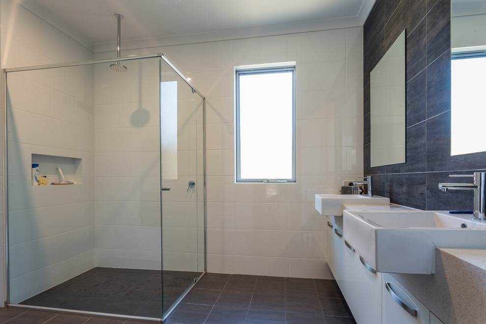 Design ideas for a mid-sized industrial master bathroom in Perth with flat-panel cabinets, white cabinets, a corner shower, white tile, ceramic tile, white walls, ceramic floors, a vessel sink, engineered quartz benchtops, grey floor and a hinged shower door.