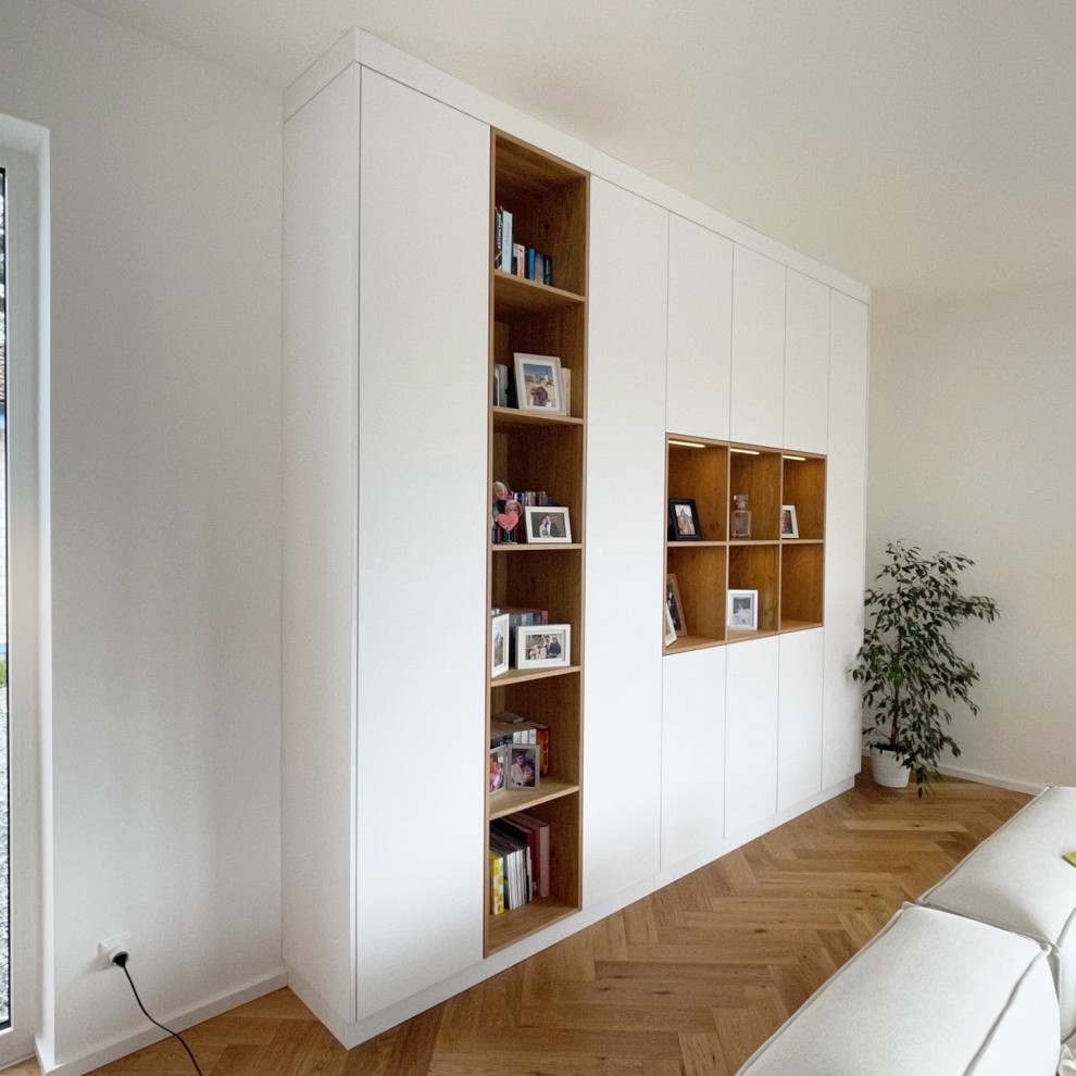 Exemple d'une salle de séjour mansardée ou avec mezzanine moderne de taille moyenne avec un mur blanc, un sol en bois brun, aucun téléviseur et un sol marron.
