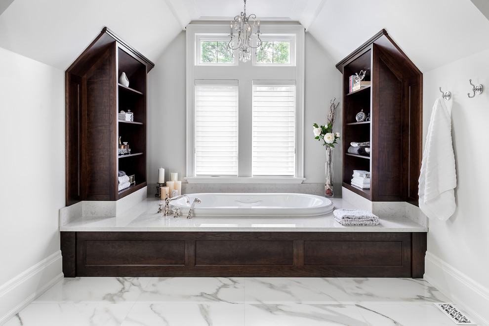 Inspiration for a large transitional master white tile and porcelain tile marble floor drop-in bathtub remodel in Toronto with recessed-panel cabinets, dark wood cabinets, quartzite countertops, a one-piece toilet and white walls