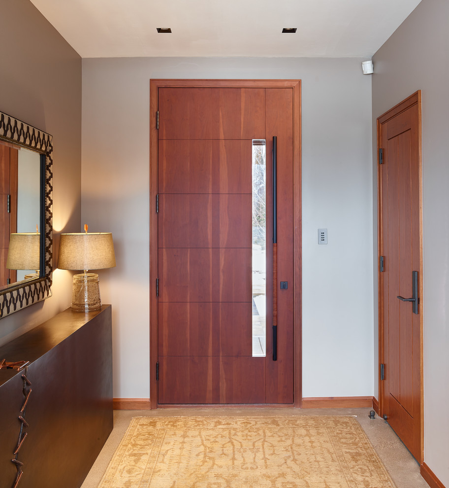 Large modern entryway in Portland with concrete floors, a single front door and a medium wood front door.