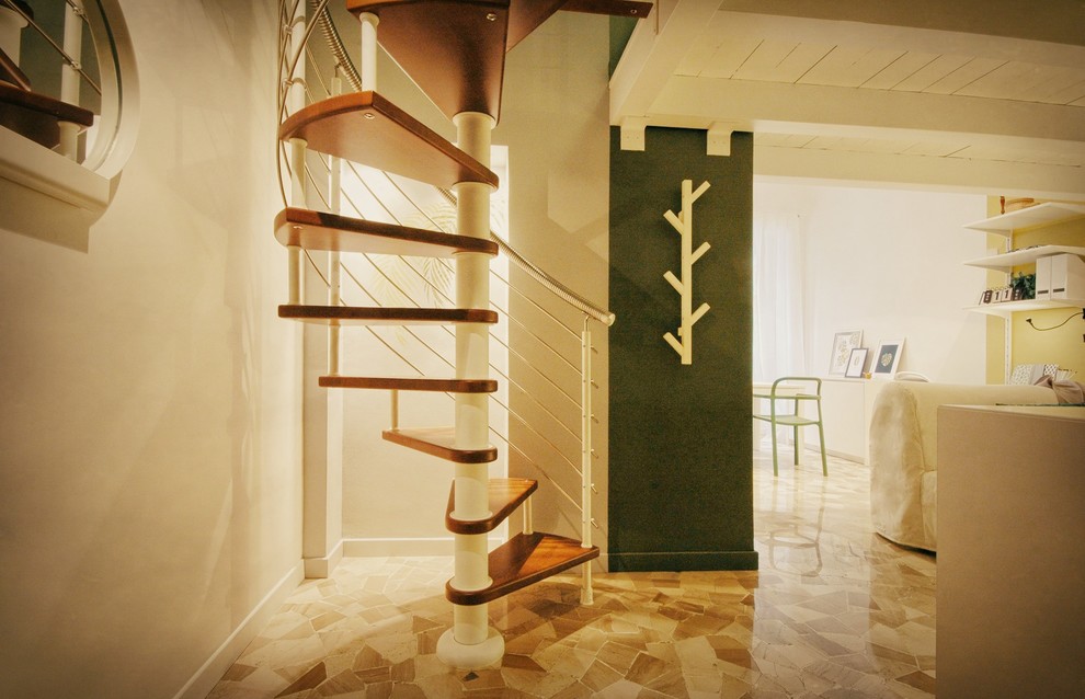 This is an example of a small contemporary foyer in Rome with green walls, marble floors, beige floor, a single front door and a dark wood front door.