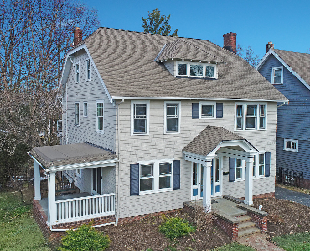 Mid-sized traditional three-storey grey house exterior in Cleveland with wood siding, a gable roof and a shingle roof.