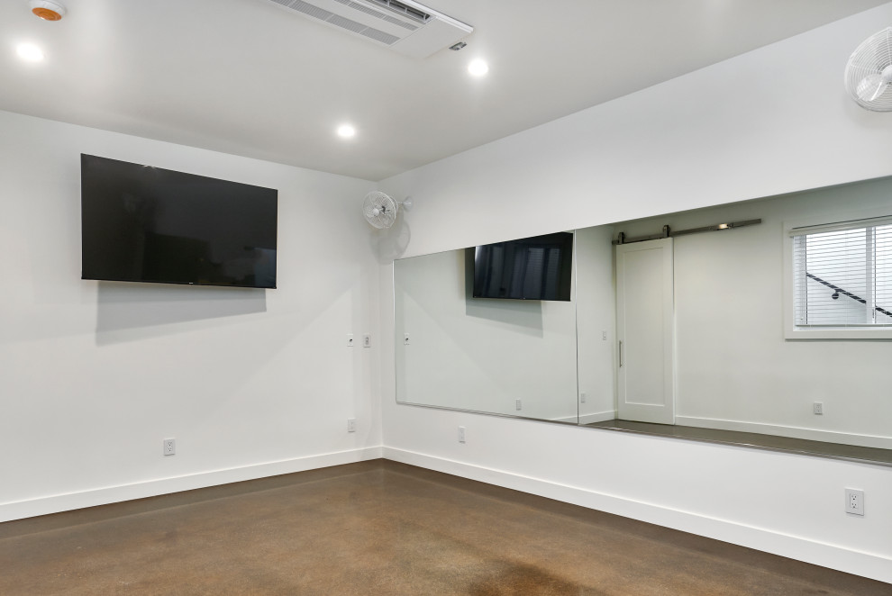 Kleiner, Multifunktionaler Uriger Fitnessraum mit weißer Wandfarbe, Betonboden und braunem Boden in San Francisco