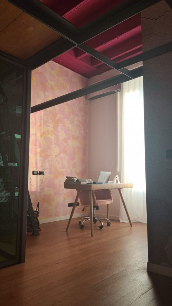 Cette image montre un petit bureau bohème avec un mur multicolore, parquet foncé, un bureau indépendant et un mur en parement de brique.