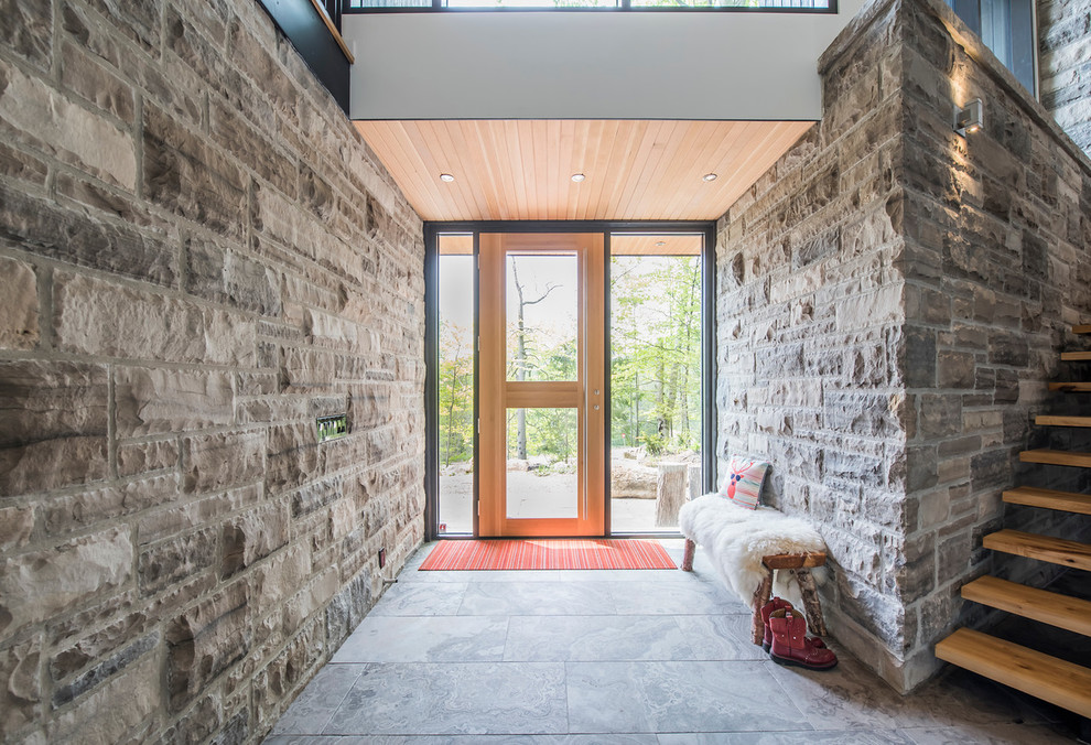 Photo of a mid-sized contemporary foyer in Toronto with limestone floors, a single front door and a light wood front door.
