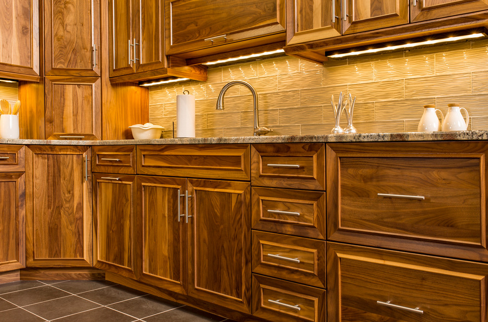 Mid-sized elegant ceramic tile and gray floor kitchen photo with recessed-panel cabinets, dark wood cabinets, granite countertops, brown backsplash and glass tile backsplash