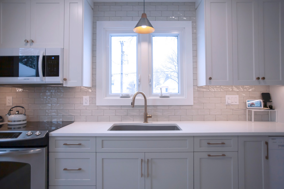 Inspiration for a mid-sized transitional single-wall eat-in kitchen remodel with an undermount sink, shaker cabinets, white cabinets, quartz countertops, porcelain backsplash, stainless steel appliances, no island and white countertops