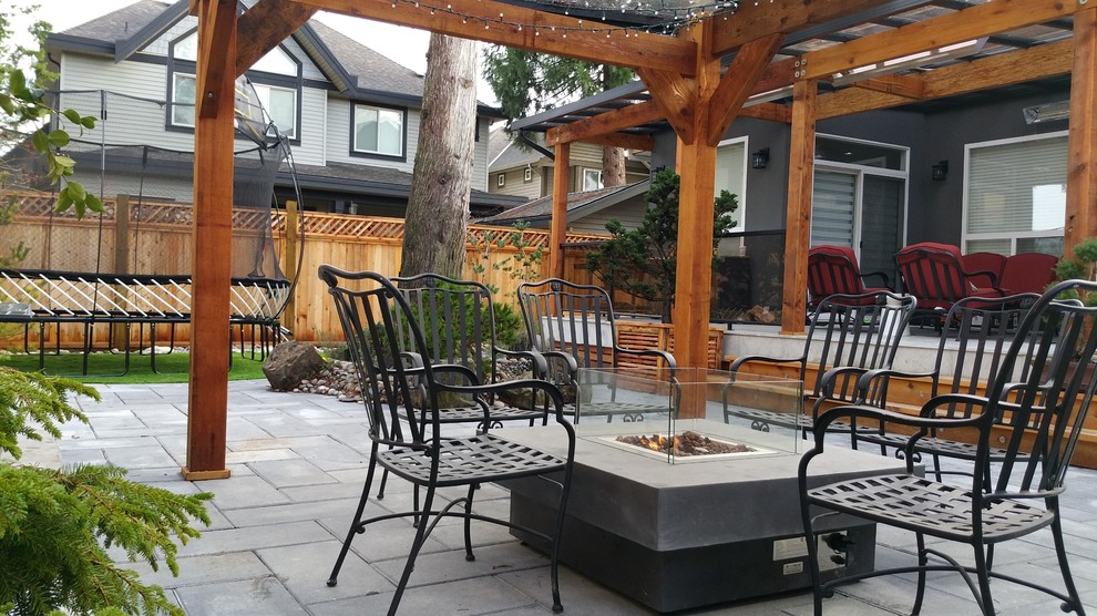 Asian backyard patio in Vancouver with a fire feature.