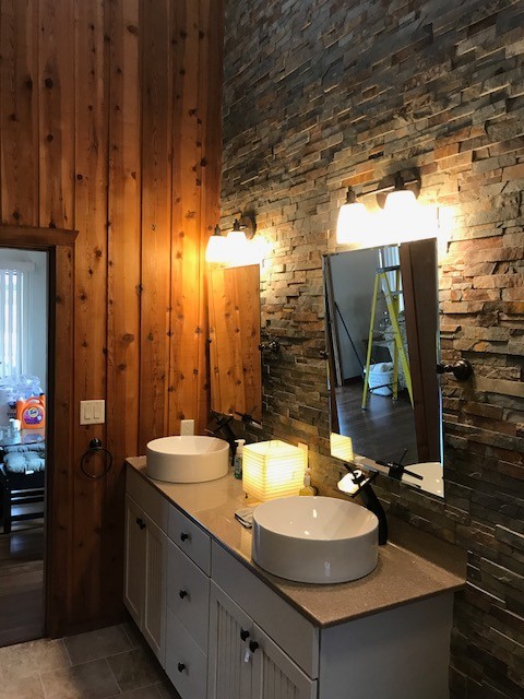 Example of a mid-sized mountain style master gray tile and stone tile ceramic tile and beige floor alcove shower design with shaker cabinets, white cabinets, laminate countertops, a two-piece toilet, gray walls, a vessel sink and a hinged shower door