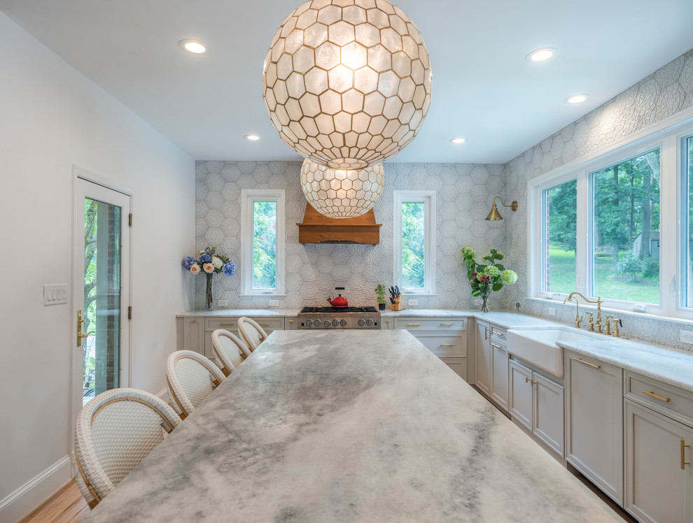 Mid-sized transitional l-shaped medium tone wood floor and brown floor enclosed kitchen photo in DC Metro with a farmhouse sink, recessed-panel cabinets, gray cabinets, granite countertops, white backsplash, stainless steel appliances, an island and gray countertops