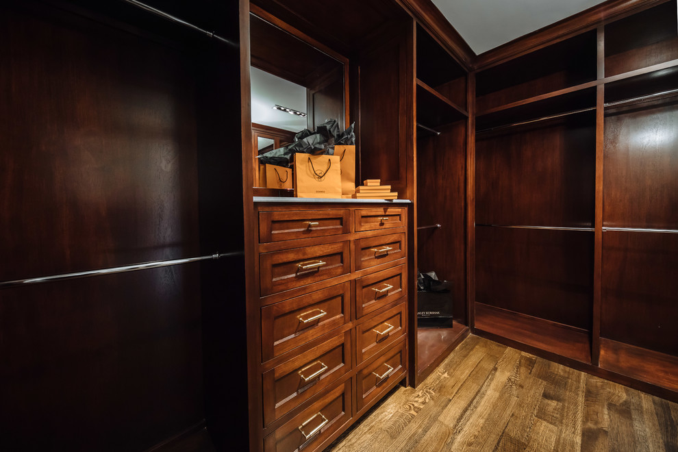 Inspiration for a mid-sized traditional men's walk-in wardrobe in Dallas with beaded inset cabinets, dark wood cabinets, light hardwood floors and brown floor.