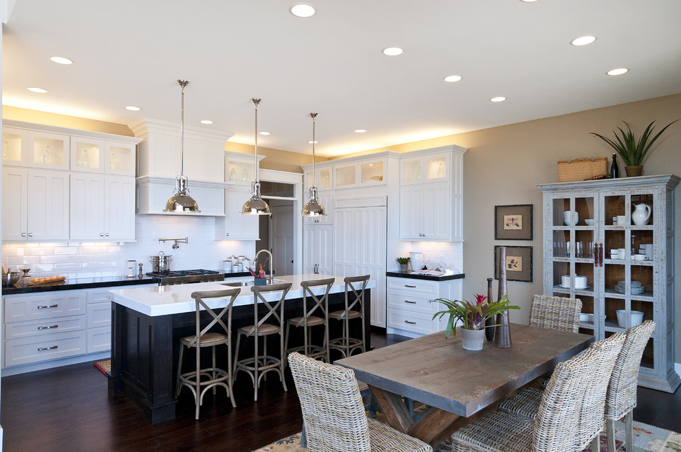 Photo of a large traditional l-shaped eat-in kitchen in Salt Lake City with shaker cabinets, subway tile splashback, an undermount sink, white cabinets, marble benchtops, white splashback, stainless steel appliances, dark hardwood floors and with island.