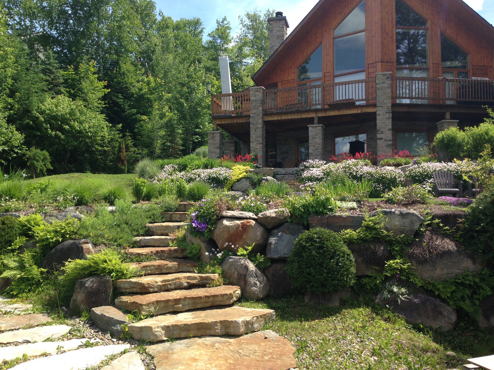 Inspiration for a country sloped full sun xeriscape for summer in Montreal with natural stone pavers.