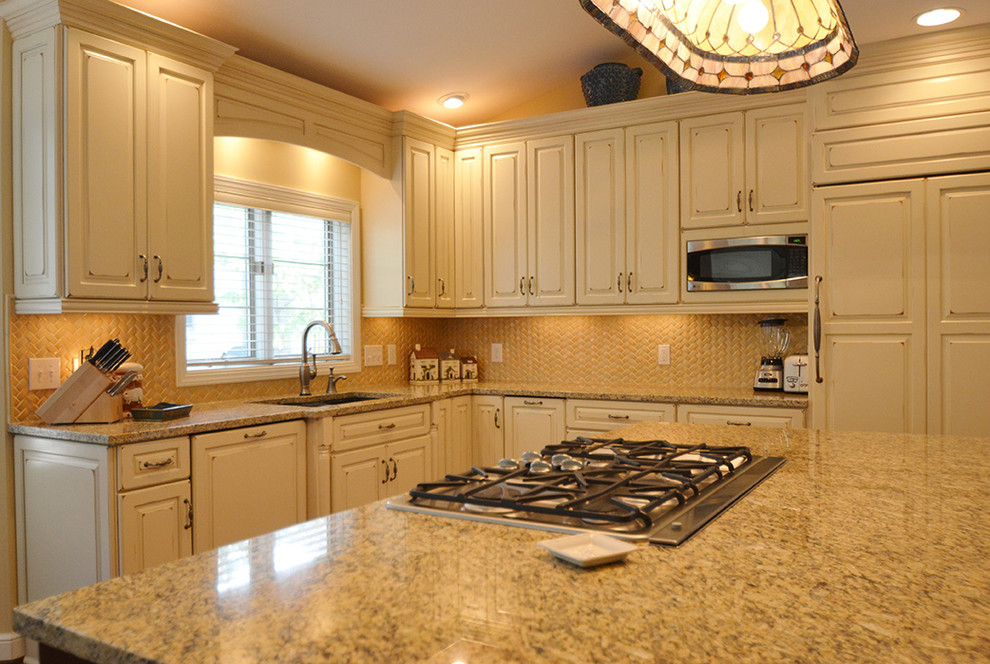 Inspiration for a large transitional l-shaped medium tone wood floor eat-in kitchen remodel in Columbus with an undermount sink, raised-panel cabinets, beige cabinets, granite countertops, beige backsplash, paneled appliances and an island