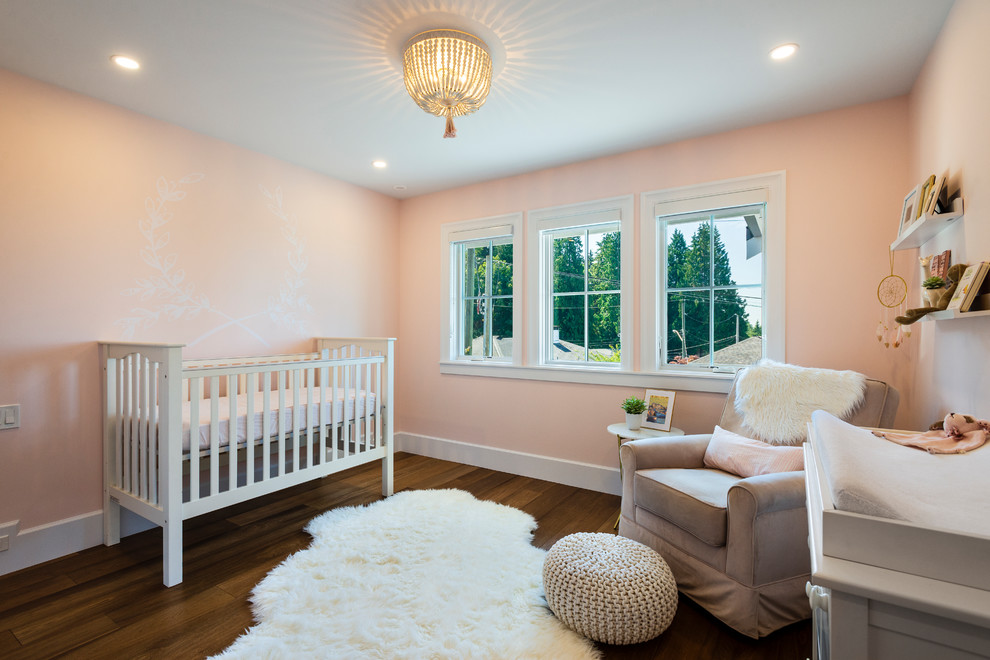 Transitional nursery in Vancouver with pink walls and dark hardwood floors for girls.