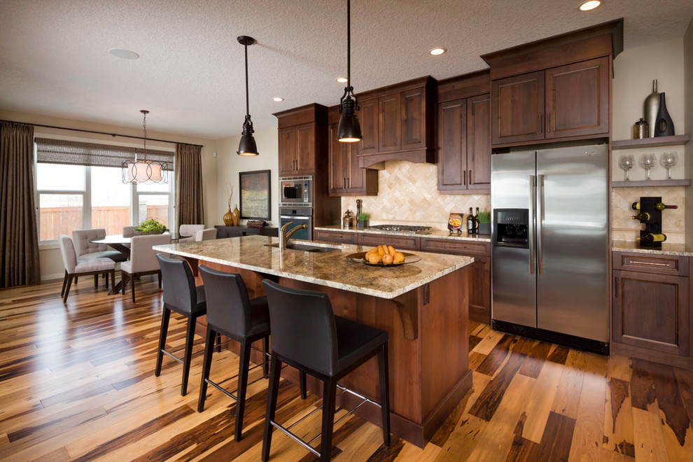 Contemporary kitchen in Calgary with stainless steel appliances and travertine splashback.