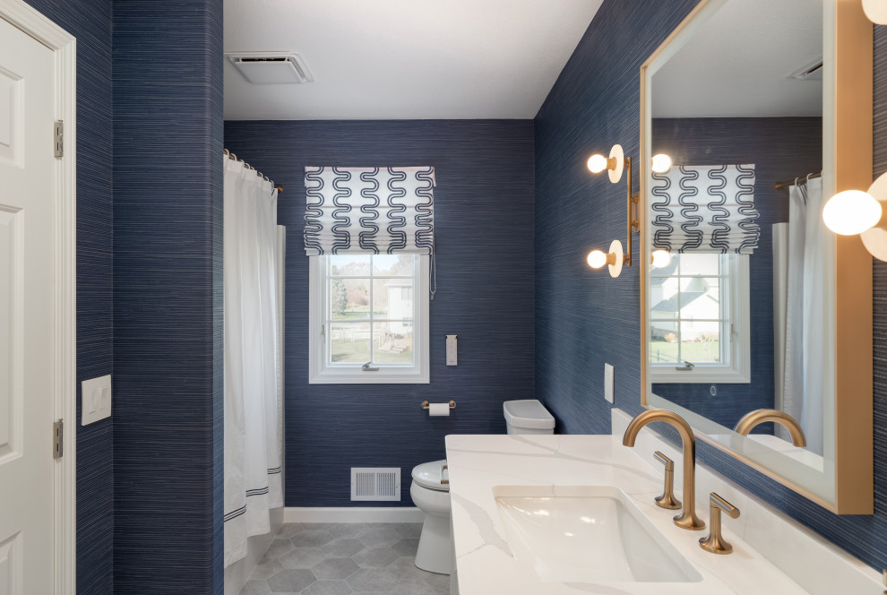 Alcove bathtub - small transitional porcelain tile, gray floor and double-sink alcove bathtub idea with shaker cabinets, white cabinets, a one-piece toilet, blue walls, an undermount sink, quartz countertops, white countertops and a built-in vanity