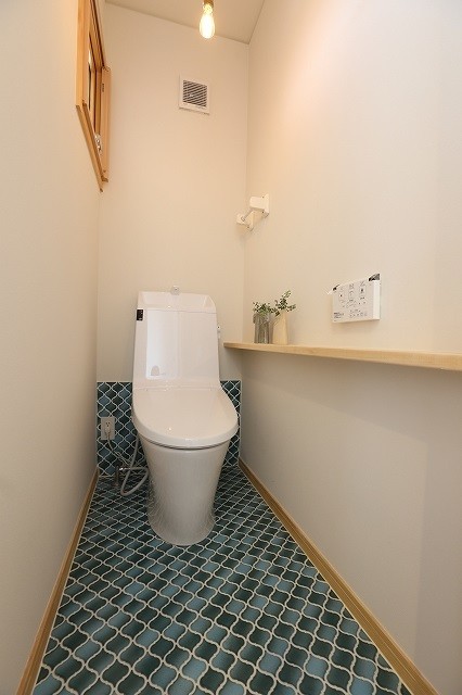 Photo of a modern powder room in Other with blue tile, porcelain tile, white walls, ceramic floors and wood benchtops.