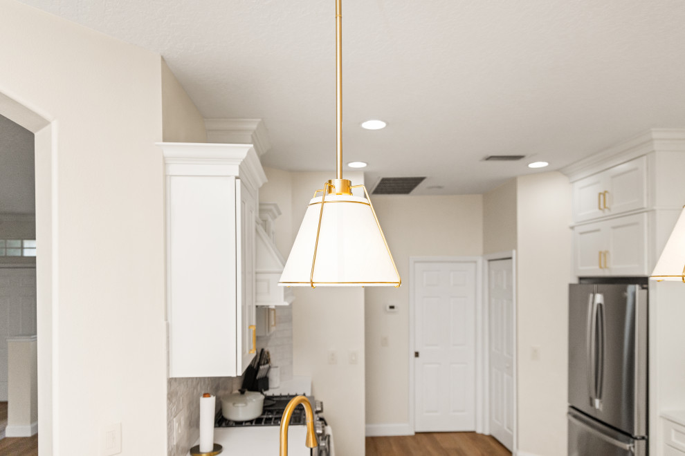 Example of a small transitional l-shaped light wood floor and multicolored floor eat-in kitchen design in Tampa with an undermount sink, shaker cabinets, beige cabinets, quartzite countertops, beige backsplash, porcelain backsplash, stainless steel appliances, a peninsula and white countertops