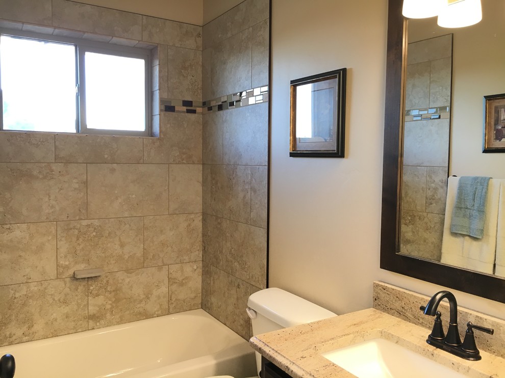 Alcove bathtub - mid-sized transitional kids' beige tile and porcelain tile porcelain tile alcove bathtub idea with raised-panel cabinets, dark wood cabinets, a two-piece toilet, beige walls, an undermount sink and granite countertops