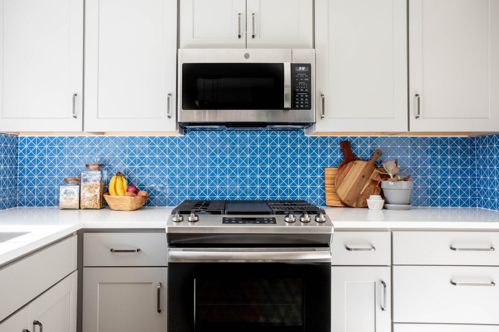 Inspiration for a mid-sized transitional l-shaped multicolored floor enclosed kitchen remodel in Austin with an undermount sink, shaker cabinets, gray cabinets, quartz countertops, blue backsplash, ceramic backsplash, stainless steel appliances, no island and white countertops
