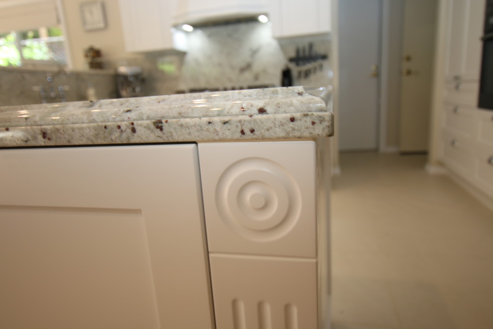 This is an example of a mid-sized traditional u-shaped eat-in kitchen in Auckland with a double-bowl sink, shaker cabinets, white cabinets, granite benchtops, white splashback, stone slab splashback, stainless steel appliances, porcelain floors and a peninsula.