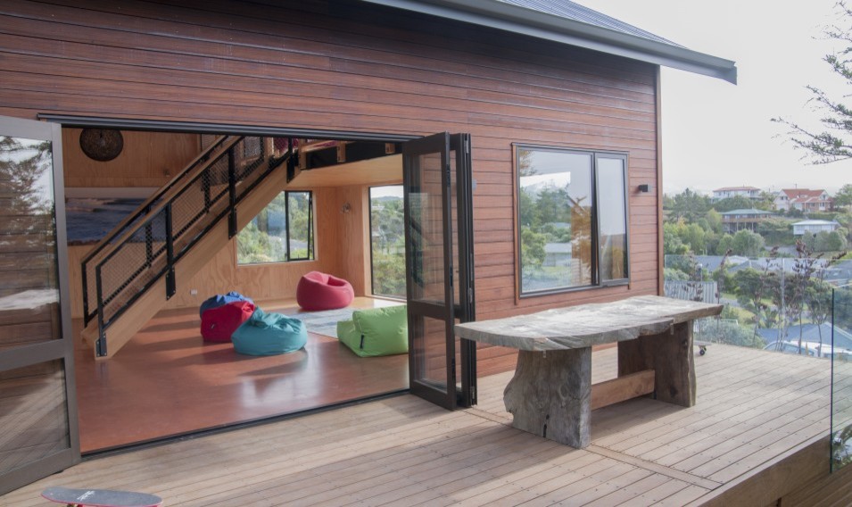 This is an example of a Small eclectic Two-storey Brown exterior in Auckland With Wood Siding and a Gable Roof.