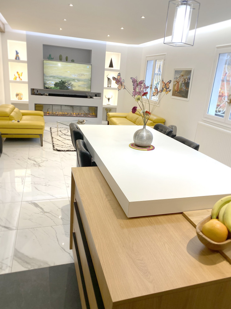 Cette image montre une salle de séjour minimaliste de taille moyenne et ouverte avec un bar de salon, un mur blanc, un sol en marbre, cheminée suspendue, un téléviseur fixé au mur et un sol blanc.