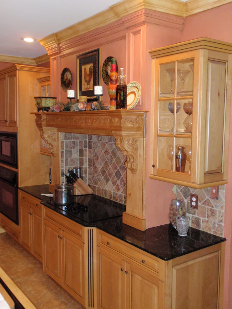 This is an example of a large mediterranean galley eat-in kitchen in Other with a double-bowl sink, raised-panel cabinets, medium wood cabinets, granite benchtops, beige splashback, stone tile splashback, black appliances, porcelain floors and with island.