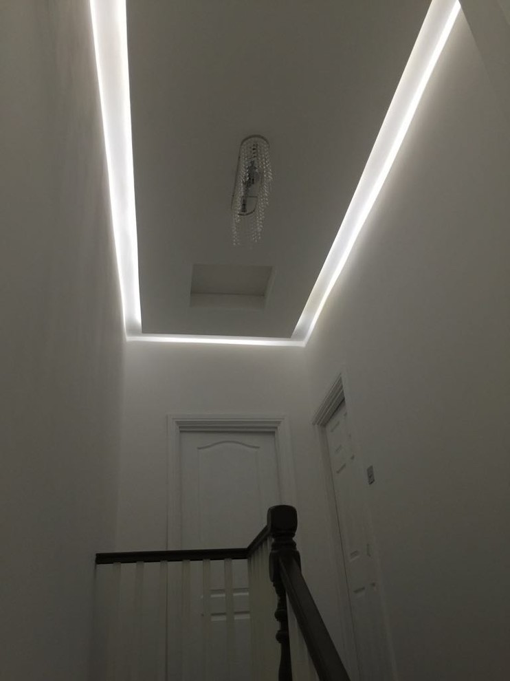 Mid-sized modern hallway in London with white walls and dark hardwood floors.
