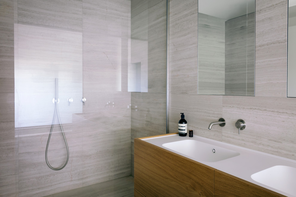 Design ideas for a large contemporary master bathroom in Milan with light wood cabinets and marble benchtops.
