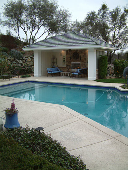 Expansive traditional backyard custom-shaped lap pool in Sacramento with a pool house and concrete pavers.