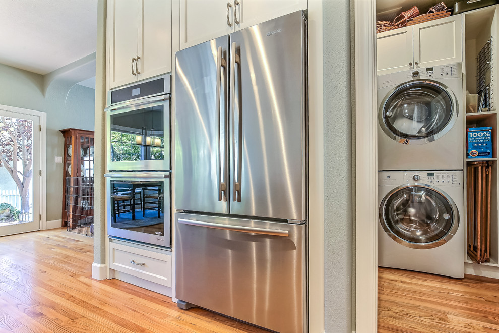 Inspiration for a mid-sized contemporary u-shaped light wood floor eat-in kitchen remodel in San Francisco with an undermount sink, recessed-panel cabinets, dark wood cabinets, marble countertops, gray backsplash, ceramic backsplash, stainless steel appliances and an island
