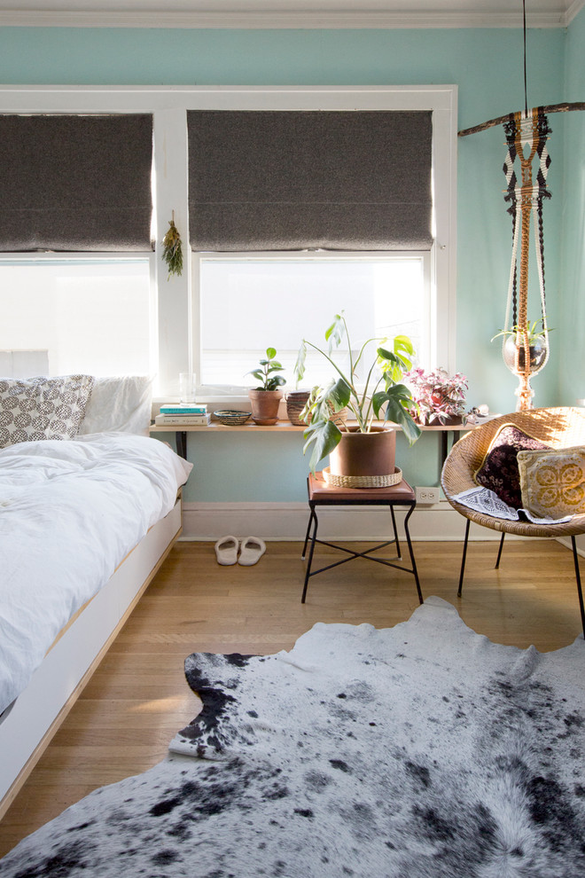 Inspiration for a small contemporary loft-style bedroom in Portland with blue walls and medium hardwood floors.