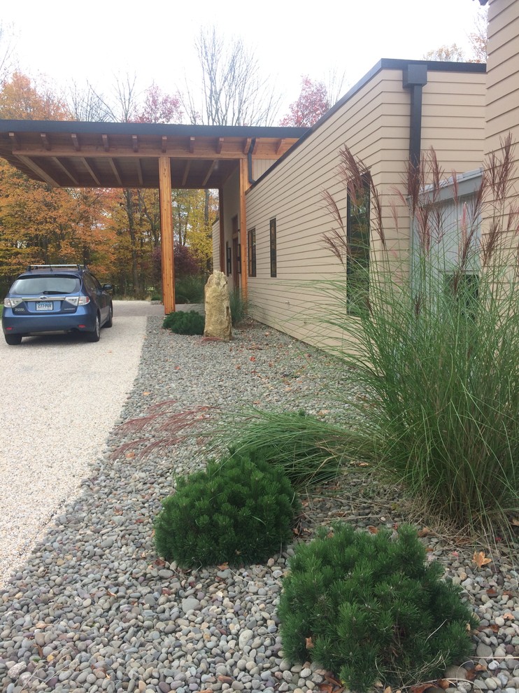 Photo of a mid-sized modern front yard full sun xeriscape in New York with gravel.