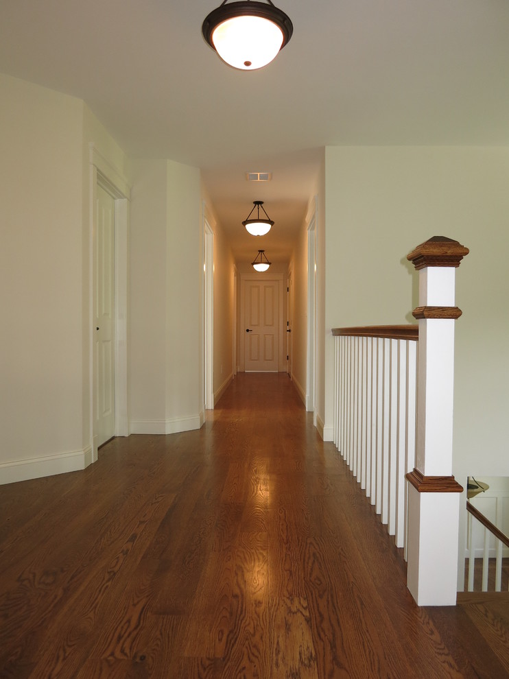 Large traditional hallway in New York with white walls and light hardwood floors.