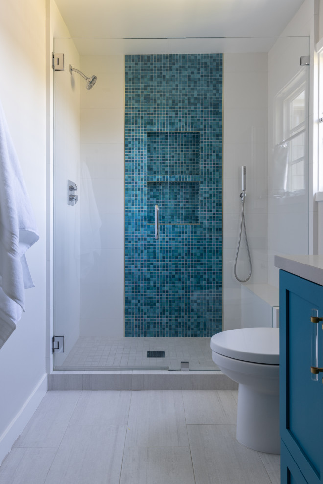 На фото: детская ванная комната среднего размера в современном стиле с фасадами в стиле шейкер, синими фасадами, душем в нише, унитазом-моноблоком, разноцветной плиткой, керамической плиткой, серыми стенами, полом из керамогранита, врезной раковиной, столешницей из искусственного кварца, белым полом, душем с распашными дверями, серой столешницей, нишей, тумбой под две раковины и встроенной тумбой с