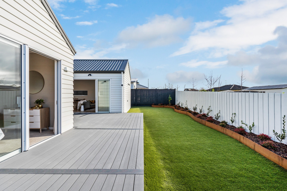 This is an example of a large modern backyard full sun formal garden for summer in Auckland with with lawn edging.