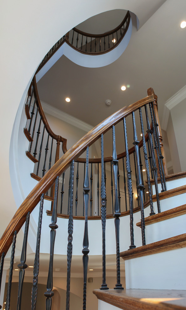 Inspiration for a large mediterranean wood curved staircase in DC Metro with wood risers and mixed railing.