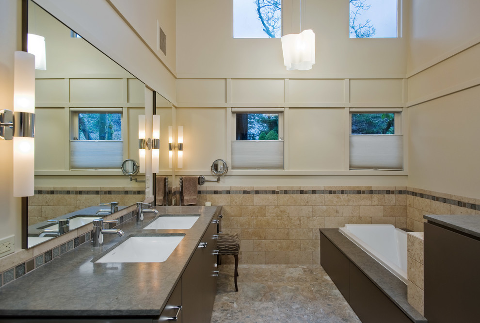 Photo of a contemporary bathroom in Seattle with an undermount sink, flat-panel cabinets, dark wood cabinets, a drop-in tub, beige tile and subway tile.
