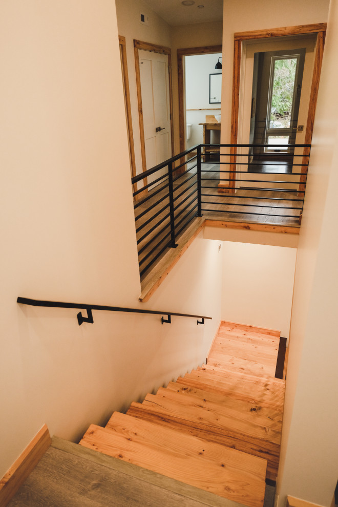 Modelo de escalera en L moderna de tamaño medio sin contrahuella con escalones de madera y barandilla de metal