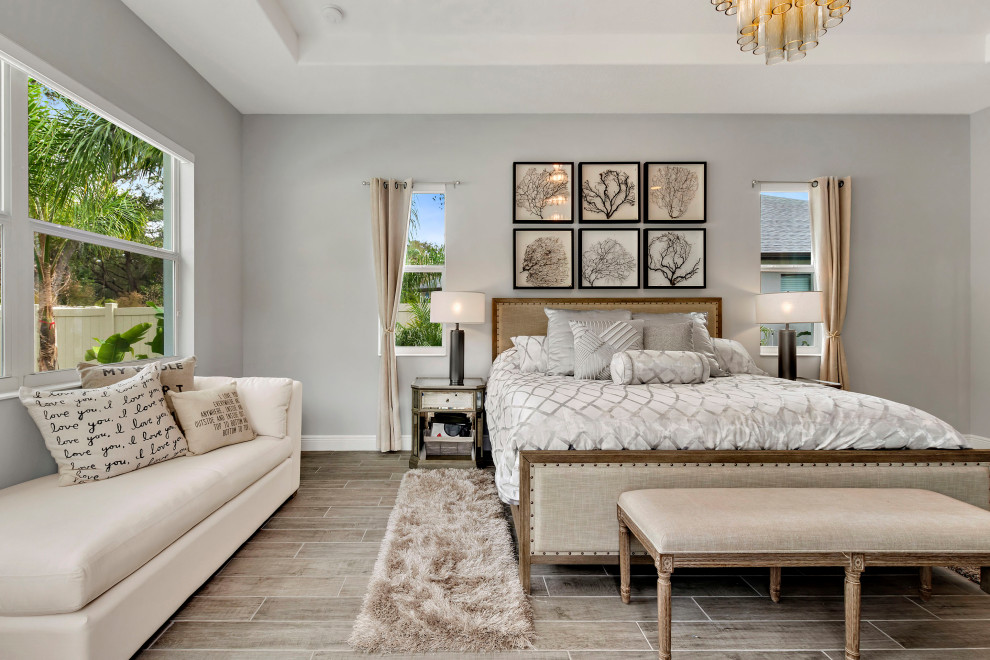 Large transitional master bedroom in Tampa with grey walls and grey floor.